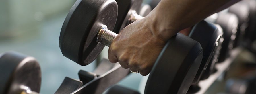 10 Mistakes People Make at the Gym - hands on a set of dumbells