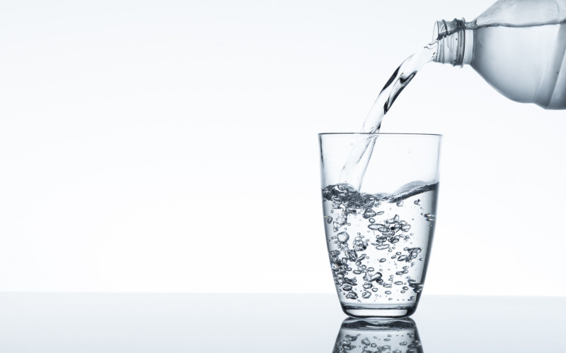 water flowing from plastic bottle into a glass water flowing from plastic bottle into a glass