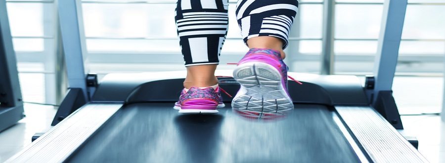 Bottom of legs and purple shoes running on treadmill