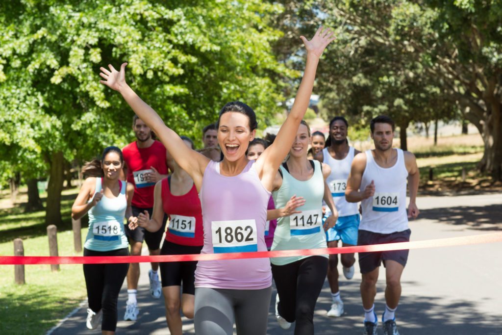 Fit people running race in park on a sunny day